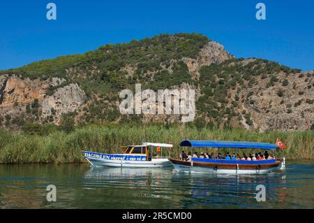 Excursion boats on the Dalyan River in front of the rock tombs of Kaunos near Marmaris, Turkish Aegean Sea, Coast, Turkey Stock Photo