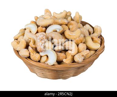 Salted roasted cashews in natural basket isolated on white background. Wicker dish full of whole or halved cashew nuts coated in salt. Delicious snack. Stock Photo