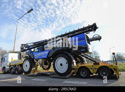 LICHTENBUSCH, BELGIUM - DECEMBER 10, 2016: Front boom agricultural sprayer, transported on a special low-loader trailer truck Stock Photo