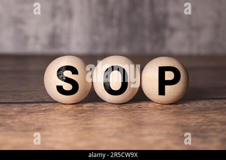 SOP - acronym from wooden blocks with letters, abbreviation SOP standard operating procedure concept, blur background Stock Photo