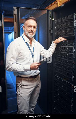 Bet you havent seen fibre speed like this before. a mature man using a digital tablet while working in a server room. Stock Photo