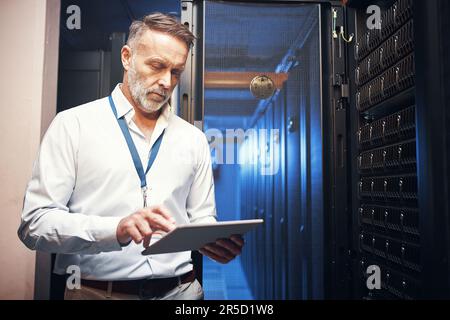 Serving up some serious safety points. a mature man using a digital tablet while working in a server room. Stock Photo