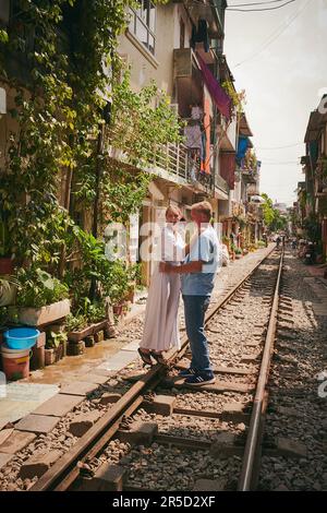 Life is beautiful with love in it. a happy couple sharing a romantic moment on the train tracks in the streets of Vietnam. Stock Photo