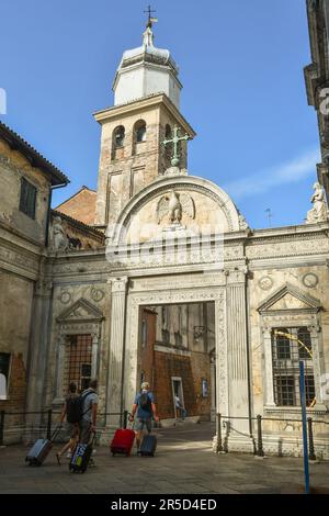 A small group of tourists with trolleys arriving at the church yard of the Scuola Grande di San Giovanni Evangelista in summer, Venice, Veneto, Italy Stock Photo