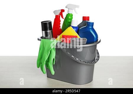 Grey bucket with car care products on wooden table against white background Stock Photo