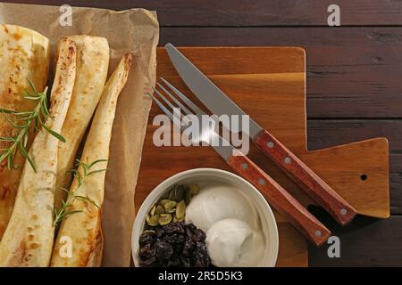 Tasty baked parsnips with rosemary served on wooden table, flat lay Stock Photo