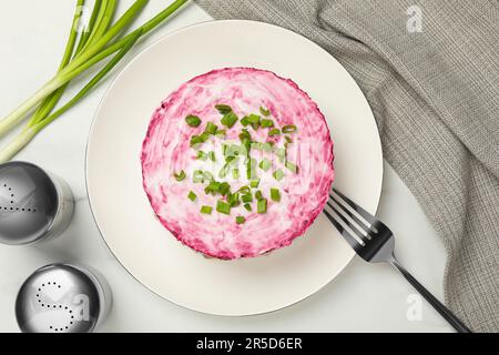 Herring under fur coat salad served on white table, flat lay. Traditional Russian dish Stock Photo