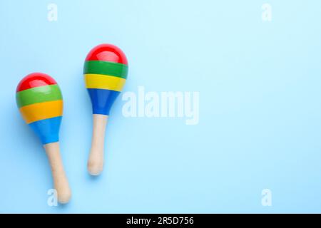 Colorful maracas on light blue background, flat lay with space for text. Musical instrument Stock Photo