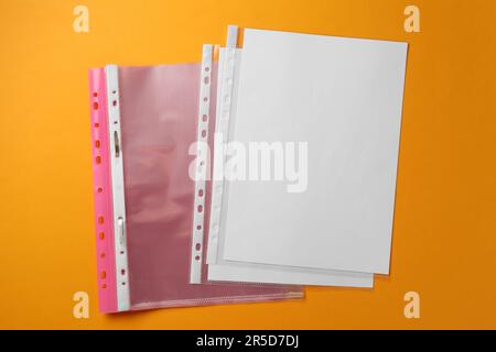 File folder with punched pockets on orange background, flat lay Stock Photo