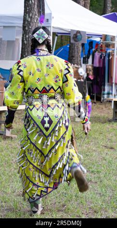 Young woman jingle dancer, a Native American woman wearing a jingle dress and beaded moccasins in the Gathering of the People Pow Wow in Evans, Georgi Stock Photo