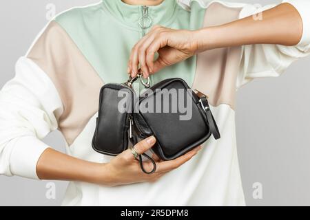 Female Hands Holding Small Black Leather Accessories for Storing Keys, Electronic Cigarette or Earphones Stock Photo