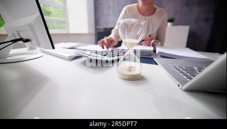 Late Invoice And Billing Deadline With Hourglass At Desk Stock Photo