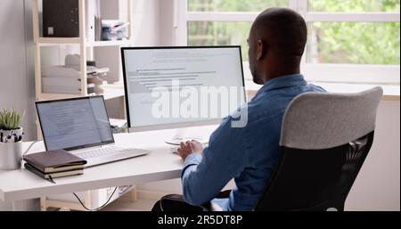 Computer Programmer Writing Program Code On Computer In Office Stock Photo