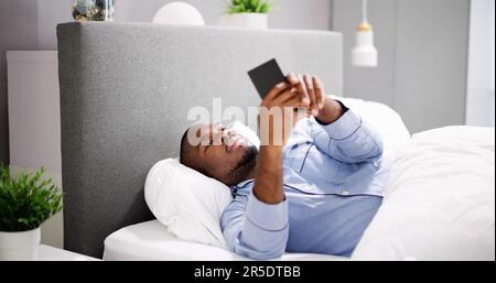 African Man Holding Smartphone Or Mobile Phone Stock Photo