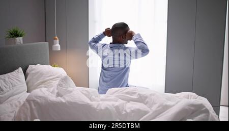 Young Happy Smiling African Man Waking Up At Bedroom Stock Photo