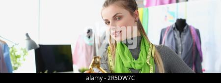 Woman seamstress stylist holding scissors in atelier. Sewing and repairing clothes in a sewing workshop concept Stock Photo