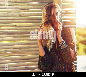 I just cant resist being myself. a fashionable young woman posing against a wooden partition. Stock Photo