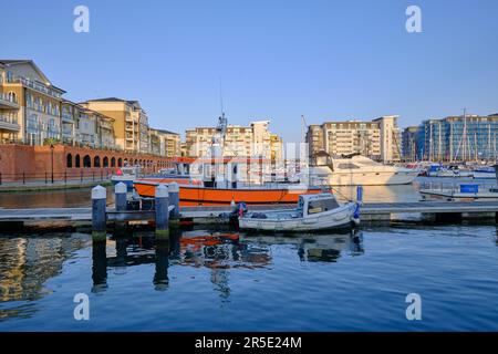 Eastbourne, East Sussex, United Kingdom - July 22 2021: Yachts in Sovereign Harbour with apartment buildings in the background.  Sunny day with blue s Stock Photo