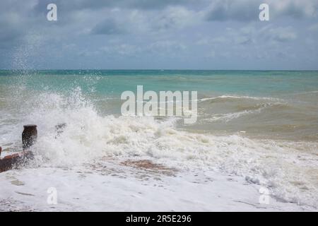 Waves crashing against wooden groyne on Eastbourne beach. Stock Photo