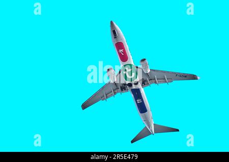 Sousse, Tunisia, January 22, 2023: Underside of a flying passenger plane for vacation flights on vacation against a blue sky Stock Photo