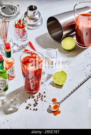 LONDON, UK - MARCH 18, 2023: Bloody mary cocktail with tabasco red and green hot sauce on light bar set up.Hard light Stock Photo