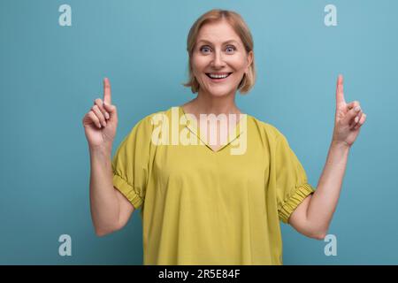 middle aged woman with insight points finger to the side in studio Stock Photo