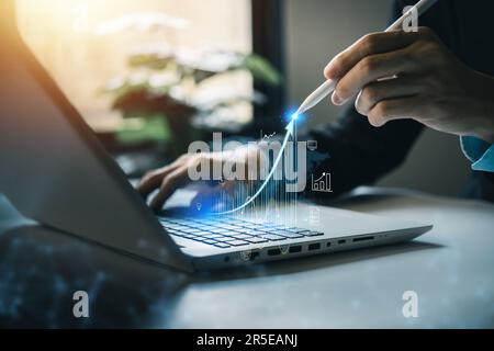 Business growing. Businessman using laptop and smartpen with virtual increasing technical graph and up arrow for trader analysis. Stock, Cryptocurrenc Stock Photo