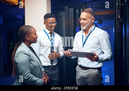 Our technicians are highly skilled in all systems. a group of technicians using a digital tablet while working together in a server room. Stock Photo