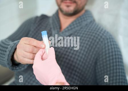 Patient takes a container with blood plasma from health worker Stock Photo