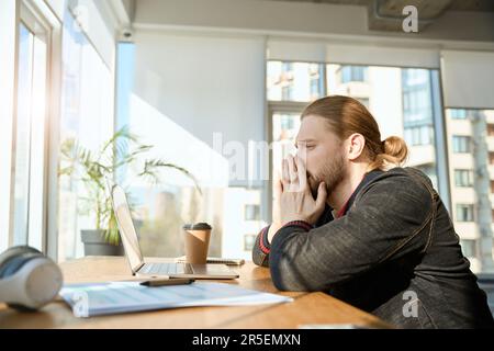 Handsome man doing work tasks at his workplace Stock Photo