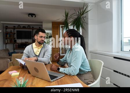 Business professionals. Group of young confident business people analyzing data using computer while spending time in the office. Workers working on n Stock Photo