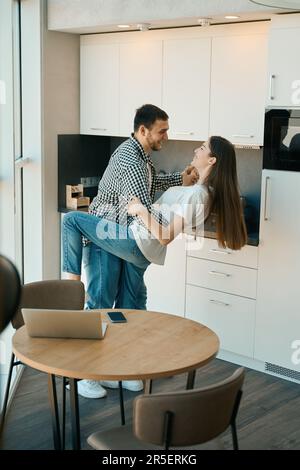 Happy beautiful young couple dancing tango in the kitchen Stock Photo