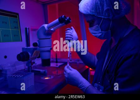 Genetic laboratory researcher taking sample from test tube in clinic Stock Photo