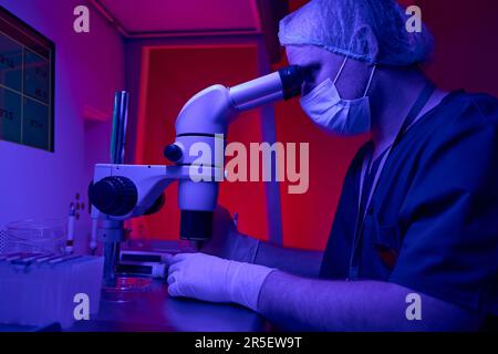 Medical laboratory scientist keeping researches looking in microscope Stock Photo