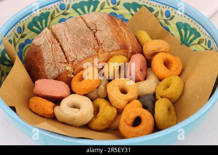 Various flavors of Apulian taralli and a sandwich in a basket on a restaurant table Stock Photo