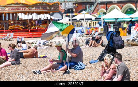 Brighton UK 3rd June 2023 - Time to get the beach umbrella out to get some shade on another hot sunny day in Brighton : Credit Simon Dack / Alamy Live News Stock Photo