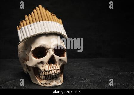Human scull with crown made of cigarettes on dark background. Stop smoking  concept Stock Photo