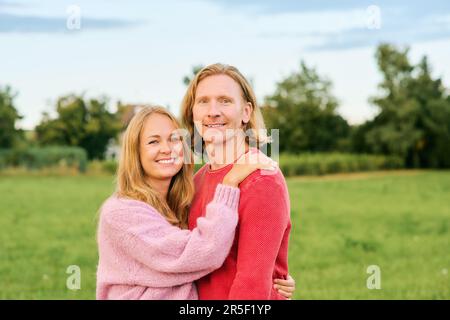 Outdoor portrait of happy young couple enjoying nice day in the nature, wearing pullovers Stock Photo