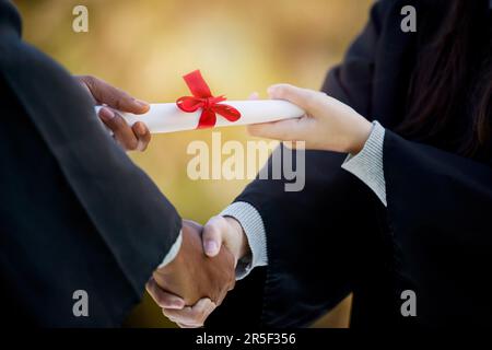Handshake, graduation diploma and people in success, achievement and congratulations or thank you. Graduate, student or person shaking hands for Stock Photo