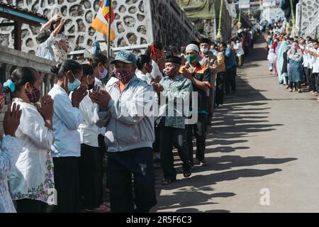 Muslim and all villagers shake hands and congratulate Buddhists who celebrate the holy day of Vesak in Thekelan village, Semarang regency, Indonesia Stock Photo