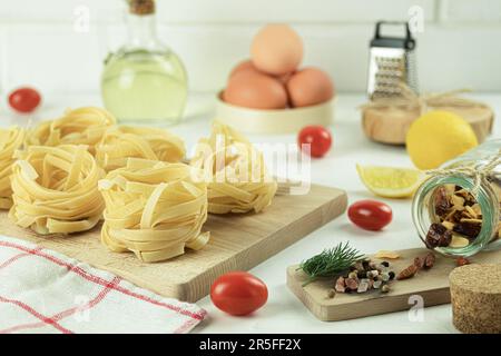 Raw and fresh homemade pasta on the table, close-up. Cooking concept. Side view on a dark background. Copy space Stock Photo