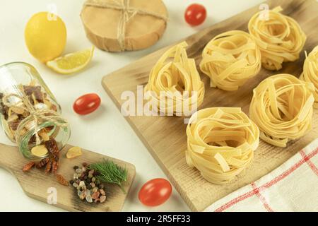 Raw and fresh homemade pasta on the table, close-up. Cooking concept. Side view on a dark background. Copy space Stock Photo