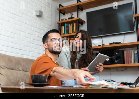 Couple architects working on interior renovation in workplace. Designers choosing color samples according to the visualization and blueprints of the p Stock Photo