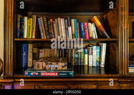 Crime novels by authors such as Jonathan Kellerman and Tana French share a bookshelf with board games like chess and Scrabble inside Huntingdon House on Satemwa Estate near Thyolo, Malawi. The guesthouse was built around 1935 and has only five rooms. Stock Photo