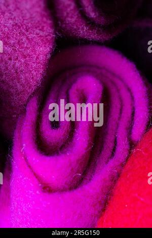 A purple ribbon of felt is rolled up into a scroll. Stock Photo
