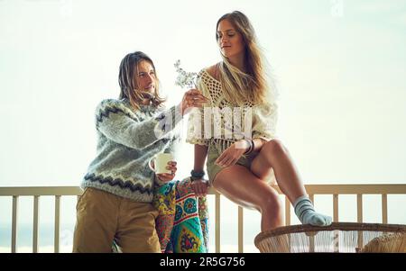 Lovely flowers for my lovely lady. a young couple relaxing on their balcony. Stock Photo
