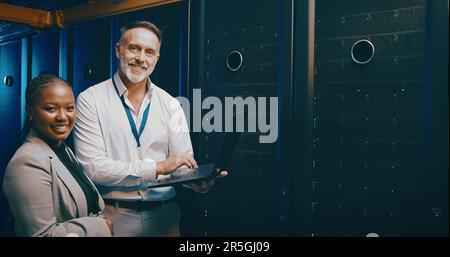 The programming pros are at it. Portrait of two technicians using a laptop while working in a server room. Stock Photo