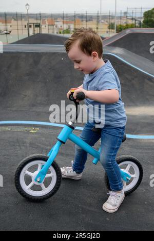 A young child rides the new South Glenmore Park BMX pump track on his bike on a summer evening in Calgary Alberta Canada. Stock Photo