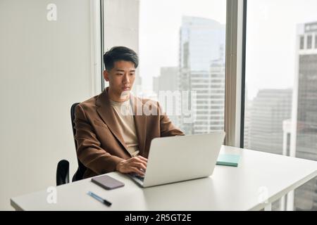 Busy professional Asian business man working using laptop in office. Stock Photo