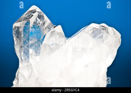 White luminous mountain crystal quartz with blue background Stock Photo